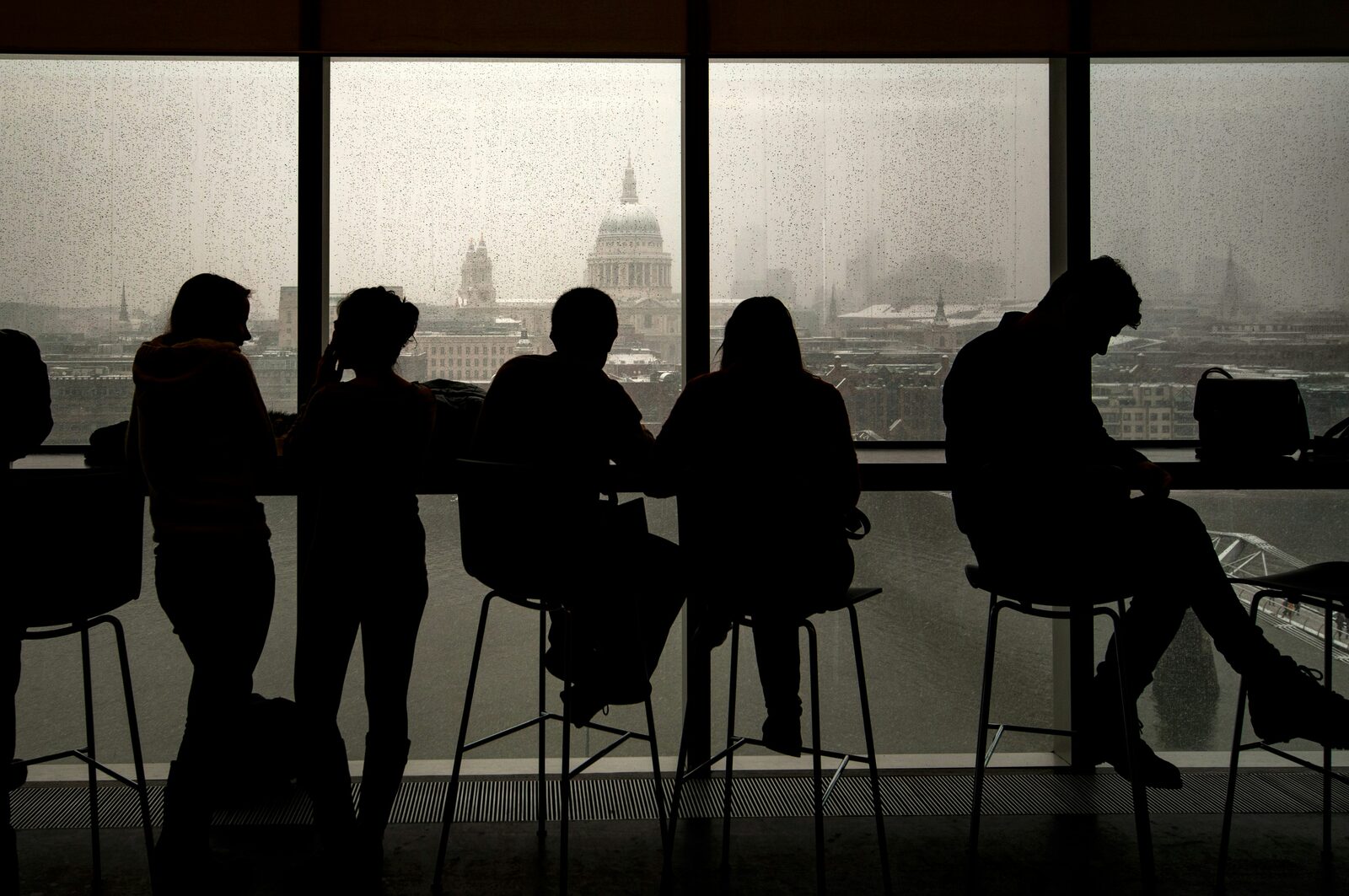 Silhouetted team seated at a window overlooking the city skyline - hitchAgentic embedded growth partner